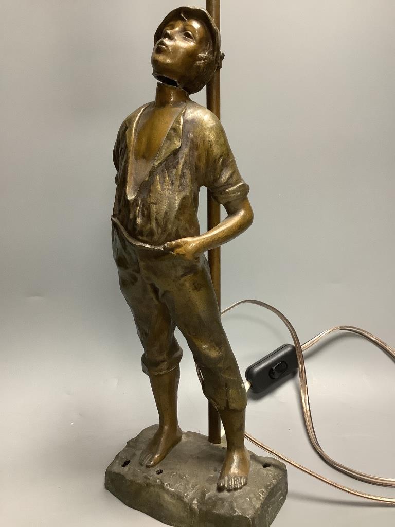 An early 20th century bronzed spelter whistling boy table lamp, 65cm.